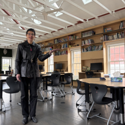 Librarian gesturing to the new collection items 
