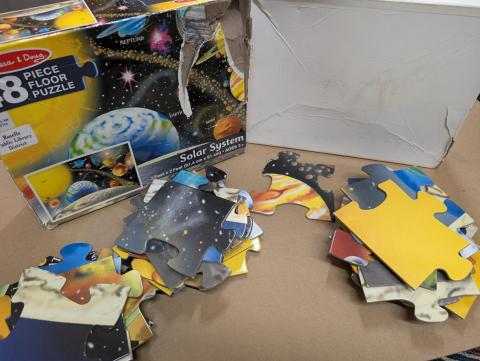 A floor puzzle, stacked in three piles with one piece on its own.