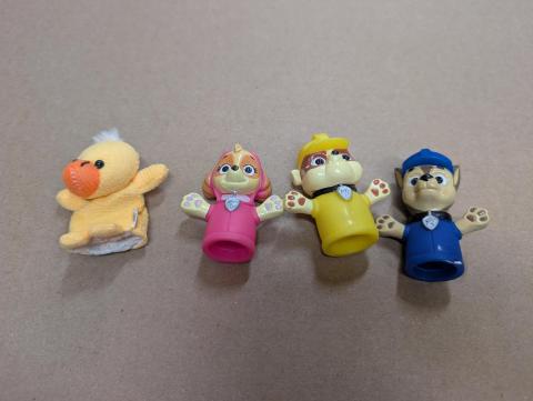 3 rubber/soft plastic Paw Patrol finger puppets and an out of place yellow duck finger puppet.